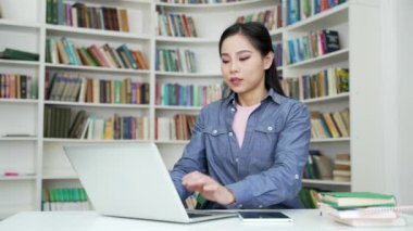 Kampüs kütüphanesinde dizüstü bilgisayarla çalışırken baş ağrısı çeken Asyalı bir kız öğrenci. Genç kadın masajını bozar, alnına ve şakaklarına masaj yapar. Fazla mesai yaptığı için çok yorgun.