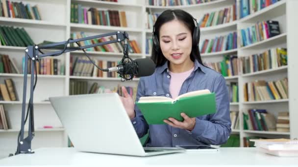 Azjatycka Nauczycielka Książką Mikrofonem Daje Lekcje Rozmowy Wideo Pomocą Laptopa — Wideo stockowe