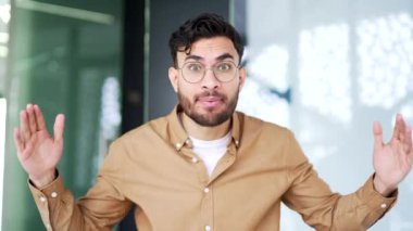 Webcam görüntüsü. Sinirli iş adamı iş yerindeki iş yerinde kameraya bakarak tartışır. Tatminsiz patron duygusal olarak bir astıyla sorunlar hakkında konuşur.