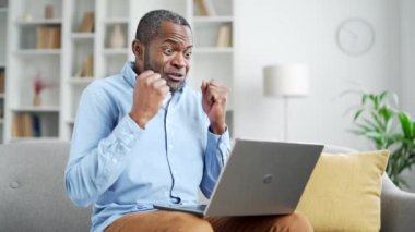 Kızgın, hoşnutsuz, olgun, Afro-Amerikan iş adamı merkez ofisteki oturma odasında kanepede otururken bilgisayarla bir video görüşmesi yapıyor. Heyecanlı bir adam, astıyla sorunlar hakkında konuşur.