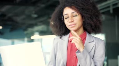 Ofiste dizüstü bilgisayarın başında oturan düşünceli, konsantre olmuş, Afro-Amerikan iş kadını problem çözmeyi düşünüyor. Siyahi kadın çalışan proje ya da girişim üzerinde çalışıyor. Kapat.