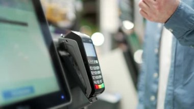 Tezgahın kapanışı. Elektronik ödeme süpermarketinin akıllı telefonu. Elinde cep telefonu olan akıllı erkek.