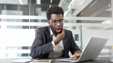 İş yerinde diş ağrısı çeken resmi takım elbiseli Afro-Amerikan işadamı. Siyahi adam elini yanağında tutuyor ve masaj yapıyor. Bir dişçiye görünmesi gerekiyor.