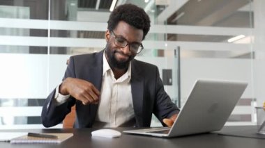 İş yerinde çalışırken bir bilgisayar faresiyle çalışırken bilek ağrısı çeken Afrikalı Amerikalı iş adamı. Üzgün siyah adam bir eklem masaj yapar, elleriyle egzersiz yapar.