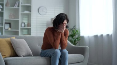 Düşünceli bir kadın depresyon geçiriyor. Evdeki oturma odasındaki koltukta oturan zihinsel acıdan muzdarip. Üzgün, yalnız, yetişkin bir kadının kişisel sorunları, stresi, endişeleri, umutsuzluğu, hayal kırıklığını hisseder.