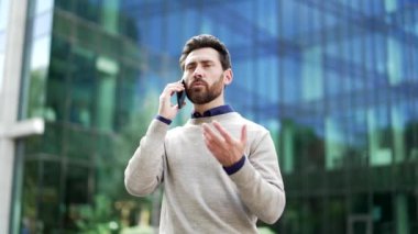 Modern bir ofis binasının yakınındaki şehir merkezinde telefonla konuşurken gülümseyen bir adam. Yakışıklı bir iş adamı iş ortağıyla iletişim kurar, iş meselelerini çözer. Bağlantı kavramı