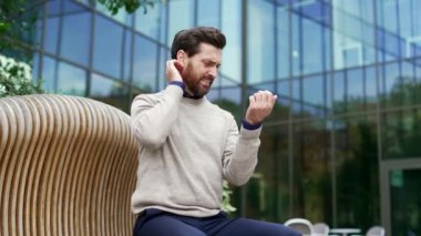 Alerji saldırısı. Kaşıntı ya da pruritus. İş adamı sokakta bankta otururken alerjik reaksiyon ya da sivrisinek ısırığı yüzünden acı çekiyor. Erkekte uyuz vardır ya da stres sonucu vücutta çizikler oluşur.