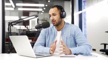 Ofiste oturan Afrikalı Amerikalı iş adamı bir video görüşmesinde konuşuyor ya da bir bilgisayar ve mikrofon kullanarak podcast kaydediyor. Erkek antrenör uzaktan konuşur, çevrimiçi konferansta sohbet eder.