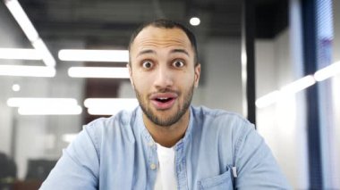 Webcam görüntüsü. Mutlu Afro-Amerikan iş adamı, iş yerindeki bilgisayar ekranına bakarak harika haberler aldı. İnsan şaşırır, şaşırır, sevinir, başarıyı kutlar.