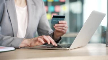 İş yerindeki kredi kartıyla çevrimiçi işlem yapmak için dizüstü bilgisayarda yazan kadın ellerini kapat. Müşteriler dijital ödeme yapar, internet, e-ticaret ve e-alışveriş için para harcarlar.