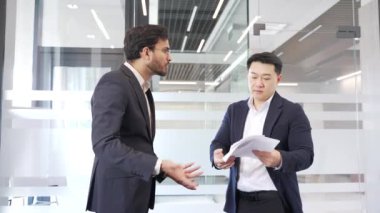 Modern ofis ortamında tartışan iki kızgın işadamı, hararetli iş tartışmaları veya anlaşmazlıklar sırasında çatışma ve duygu gösteriyorlar. Meslektaşlar agresif dövüş, tartışma, tartışma