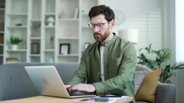 Öfkeli işadamı, ofisteki koltukta oturan dizüstü bilgisayarında yazılımla ya da servisle ilgili sorunlar yaşıyor. Hayal kırıklığına uğramış sakallı adam kötü internet bağlantısından şikayetçi.