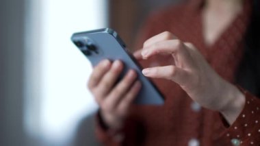 Modern oturma odasında cep telefonu kullanarak kadın ellerini kapat. Genç Asyalı kadın dijital iletişimde, sosyal medyada geziniyor ya da internette sohbet ediyor. Teknoloji kullanımı, bağlantı kavramı