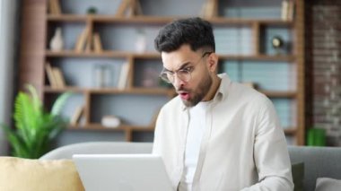 Hüsrana uğramış genç bir adam evdeki oturma odasında kanepede otururken dizüstü bilgisayarından kötü haberler okuyor. Endişeli sakallı adam üzgün bilgisayarda olumsuz mesajı incelerken kameraya bakıyor.