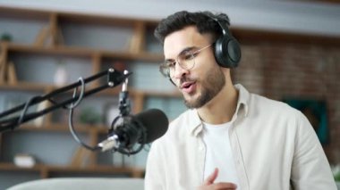 Özgüveni olan bir adam ofisteki bilgisayarı ve mikrofonu kullanarak podcast 'i kaydediyor. Kulaklıklı erkek vlogger çevrimiçi yayın röportajı ya da webinar yapar, video aracılığıyla uzaktan konuşur. Kapat.