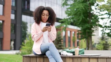 Afro-Amerikan kız öğrencilerin üniversite binasının yakınındaki bir bankta otururken telefonla kötü haberler okuması şok edici. Üzgün genç siyah kadın olumsuz bir mesaj alınca hayal kırıklığına uğradı.