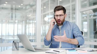 Kızgın iş adamı ofisteki iş yerinde cep telefonuyla konuşuyor. Heyecanlı hoşnutsuz yönetici stresli iş durumunu ya da çatışma çözümünü çözüyor. Patron astını azarlar.