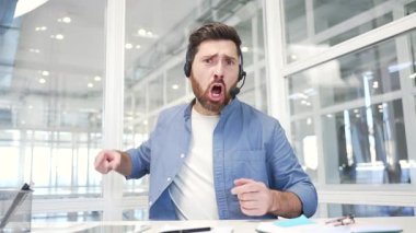 Webcam görüntüsü. Kulaklık takmış kızgın iş adamı video konferansında tartışarak ofisteki kameraya bakıyor. Heyecanlı memnuniyetsiz yönetici stresli iş durumunu ya da çatışma çözümünü çözüyor