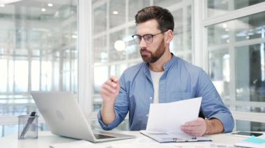 Finansör, iş yerindeki bir masada otururken dizüstü bilgisayarla evrak işleriyle uğraşıyor. Düşünceli yakışıklı iş adamı mali raporlarla ilgileniyor, muhasebe ile meşgul.