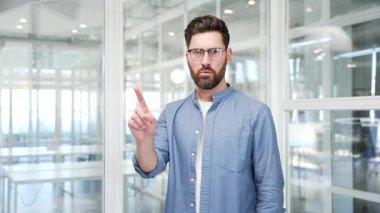 Ciddi bir iş adamı, işaret parmağı iş ofisinde kameraya bakarken işaret parmağını sallıyor. Çapraz kollar gösteren bir adam, X işareti, bir yasaklama hareketi gösteriyor, inkar, anlaşmazlık
