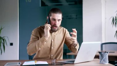Kızgın iş adamı ofisteki iş yerinde cep telefonuyla konuşuyor. Heyecanlı hoşnutsuz yönetici stresli iş durumunu ya da çatışma çözümünü çözüyor. Patron astını azarlar.
