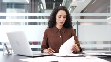Kendine güveni tam bir iş kadını iş yerindeki bir masada oturan belgeleri imzalıyor. Bir kadın yönetici evrakları karıştırır, kontrol eder ve sözleşmeyi kalemle imzalar
