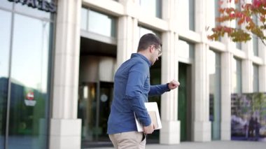 İş adamı kol saatine bakar ve ofis binasına koşar. Bir erkek işçi işe geç kalır. Bir girişimci toplantıya koşa koşa gider. Adamın iş görüşmesi için acelesi var. Arka görünüm