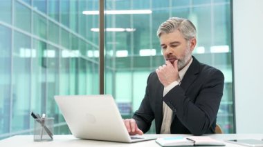 İş yerinde dizüstü bilgisayarla çalışan düşünceli bir iş adamı. Müdür, iş yerinde problem çözmeyi düşünüyor. Resmi takım elbiseli işçi ya bir görevdedir ya da bilgisayar projesiyle meşguldür.