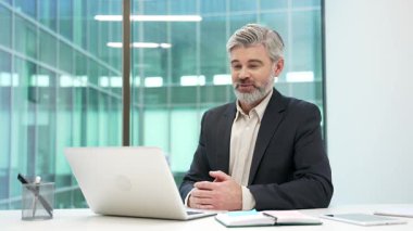 Ofisteki bir video konferansında dizüstü bilgisayarla konuşan kendinden emin bir iş adamı. Müdürün bir iş toplantısı var. Koç çevrimiçi eğitim, danışmanlık, sınıf, kurs veya webinar 'a sahip.