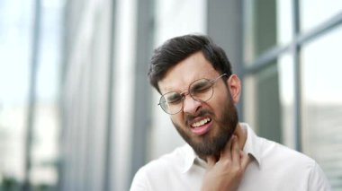 Hasta işadamı, iş yerinin yakınındaki caddede dikilirken boğaz ağrısı çekiyor. Sağlıksız bir adam öksürüyor, soğuk algınlığı, virüs ya da grip. Hassas bir noktaya masaj yapan hasta bir erkek. Kapat.