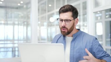 Kızgın iş adamı iş yerinde oturan dizüstü bilgisayarla görüntülü konuşma yapıyor. Heyecanlı hoşnutsuz yönetici stresli iş durumunu ya da çatışma çözümünü çözüyor. Kapat.