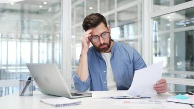 İşadamı evrak işlerinden ve iş yerindeki işyerinde oturmaktan bıktı. Kafası karışmış işadamı belgelerle uğraşmakta zorlanıyor. Yorgun erkek işçi oyalanıyor.