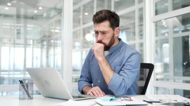 Modern bir iş yerinde masa başında otururken sağlıksız bir işadamı öksürüyor. Soğuk algınlığı ya da grip hastası kendini kötü hissediyor, kendini iyi hissetmiyor, elini göğsüne dayıyor. Bronşiti var.