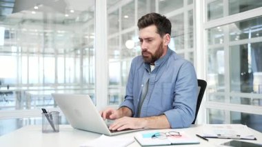 İşadamı, modern bir iş ofisinde çalışırken dizüstü bilgisayarda donup kaldı. Erkek üşütmüş. Mutsuz işçi, düşük sıcaklıktan dolayı rahatsızlık hissediyor. Isıtma sorunu