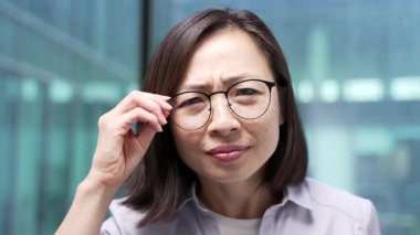 Webcam görüntüsü. Ofiste otururken kameranın dizüstü bilgisayarına şaşırmış Asyalı mutlu iş kadınına yakından bakın. Şok olmuş kadın kadehleri atıyor. Keyifli içerik ya da iyi haberler.