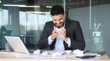 Yorgun ve stresli işadamı, iş yerindeki masasında oturarak evrak işlerinden sıkılıyor. Takım elbiseli çok çalışan üzgün bir çalışan yorgun. Hayal kırıklığına uğramış işçiler depresyon ve umutsuzluğa kapılırlar.
