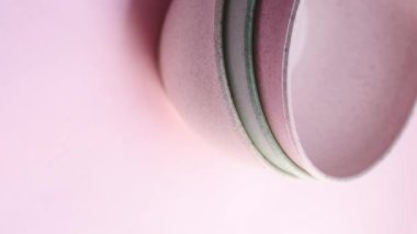 Pembe arka planda pembe seramik çömlekleri alan el videosu.