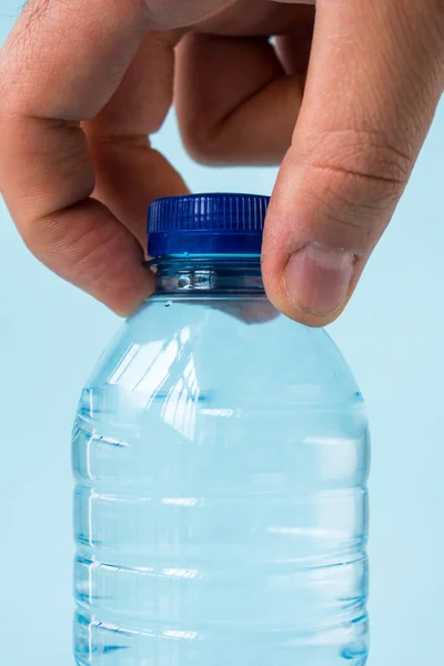 Prendendo Mano Bottiglia Acqua Sfondo Blu — Foto Stock