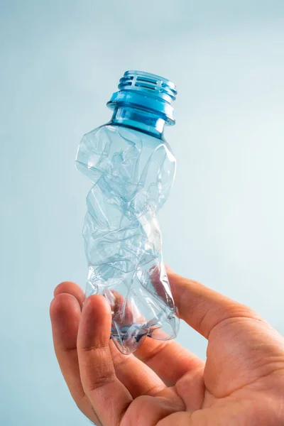 Hand Houden Plastic Gestripte Fles Blauwe Achtergrond — Stockfoto