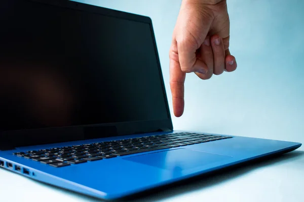 Hand touching a blue laptop on blue background