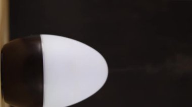 Bir odada buharlı hava spreyini kapatırken çekilmiş dikey bir video.