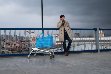 Market car and man talking on his phone in a parking