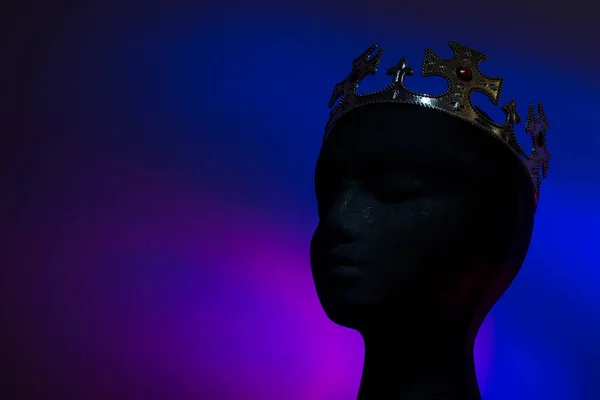 Bright crown on black head on black background