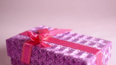Hand taking a gift box on pink background