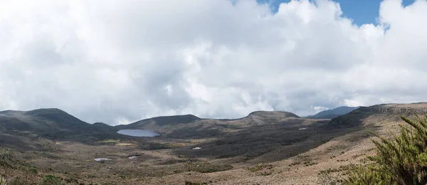 Rocky paramo landscape with fog and lake in a cloudy day