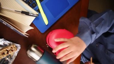 Ofisteki kadının kalp şeklinde bir yemek konteynırını açtığı dikey video.