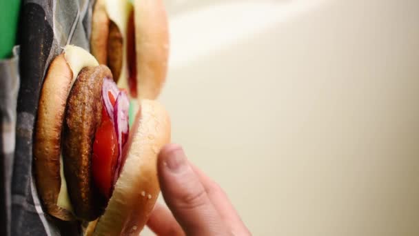 野菜とパンと手で1つを取るいくつかの新鮮なハンバーガーの垂直ビデオ — ストック動画