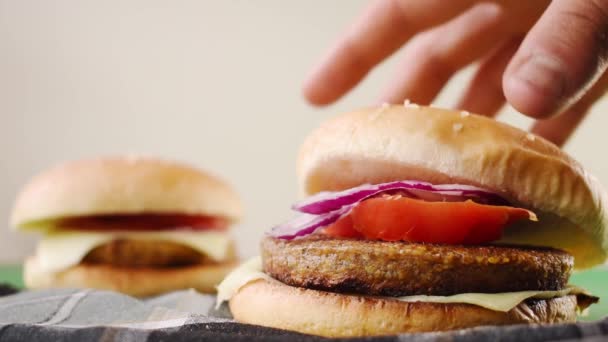 野菜とパンと手で1つを取るいくつかの新鮮なハンバーガー — ストック動画