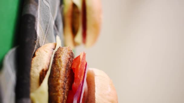 Függőleges Videó Néhány Friss Hamburgerről Zöldségekkel Kenyérrel Zöld Asztalon — Stock videók