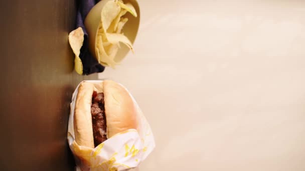 チップと配達紙袋から牛肉バーガーを取る手の垂直ビデオ — ストック動画